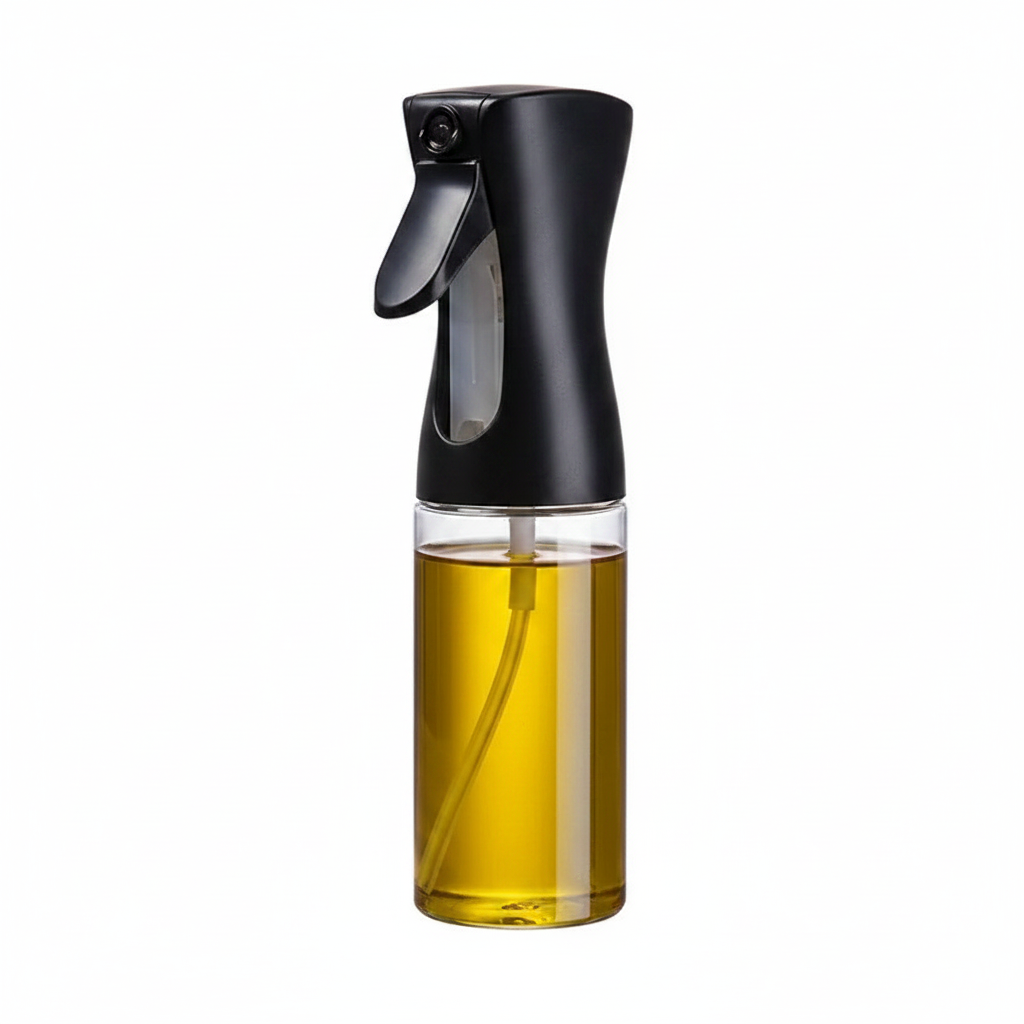 Oil spray bottle with black handle and clear body filled with golden olive oil on white background