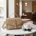 Lifestyle photo of the khaki satchel on a marble cafe table